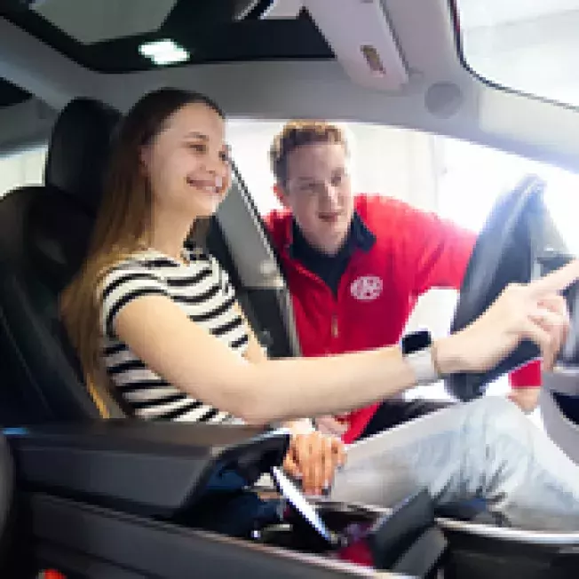 Customer and CAA employee learning inside features of a EV car