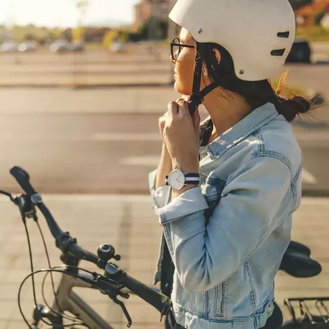 Woman putting on her bike helmet