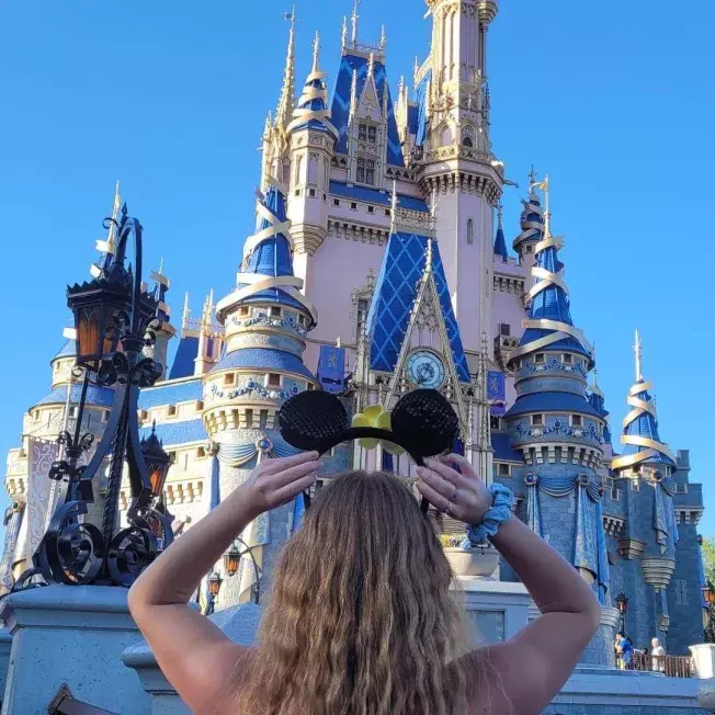 A little girl looking up at the disney castle