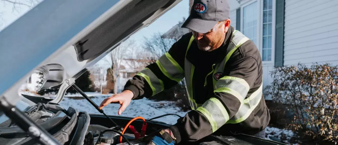 CAA attendent working under the hood of a car