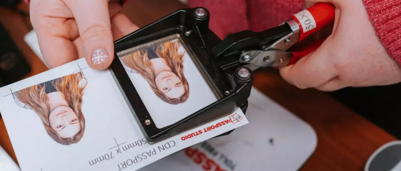 Female hand cutting a passport photo