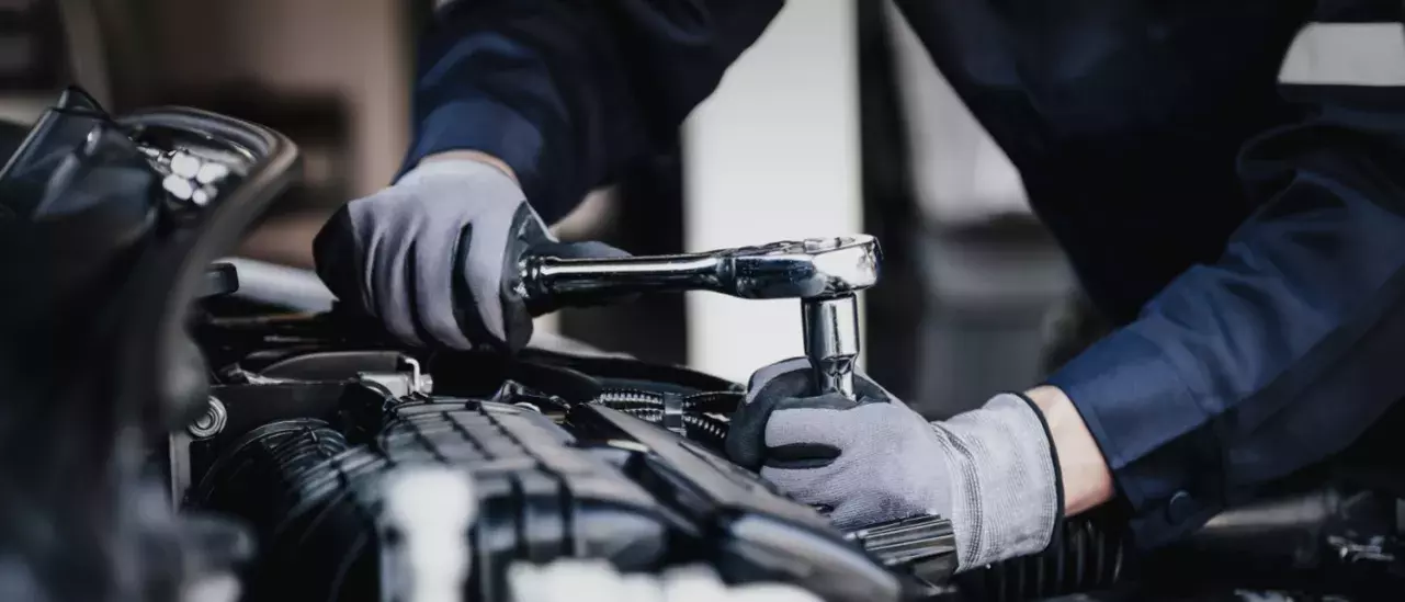 Worker working on an engine with a wrench
