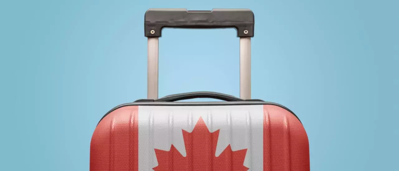 Suitcase with Canada Flag printed on it on a light blue background