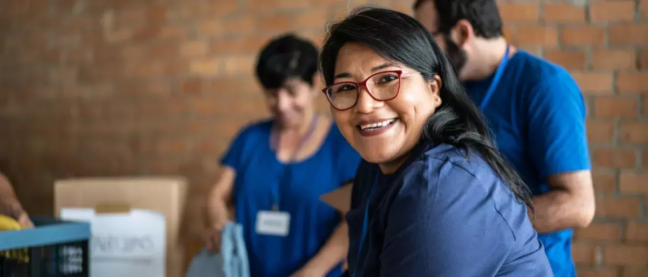 3 people volunteering in blue tshirts