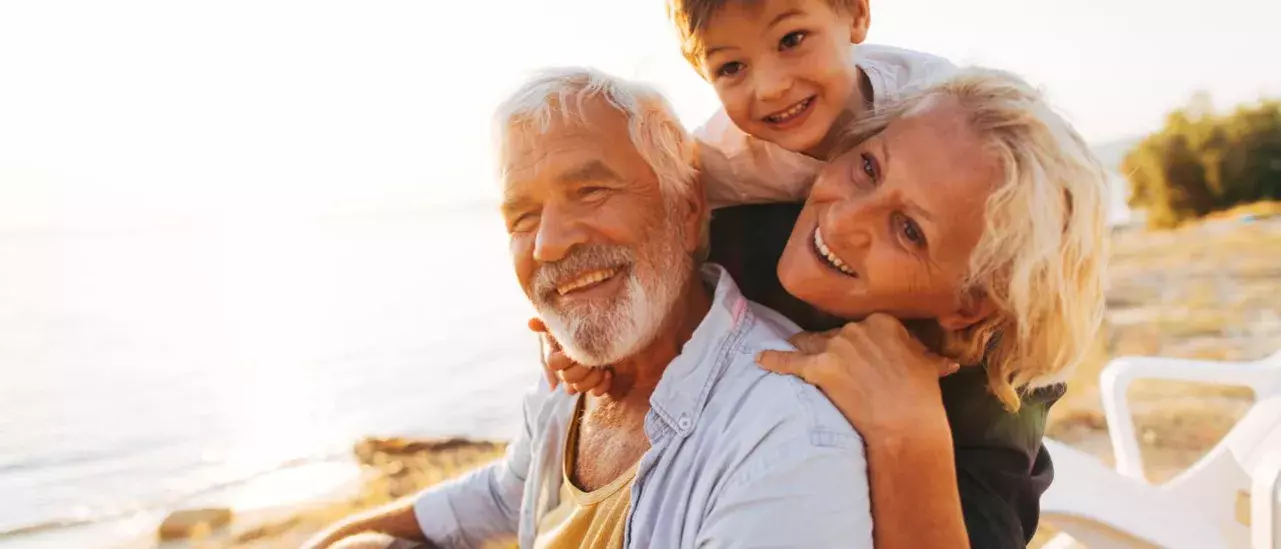 Grandparents with grandchild playing at the beach