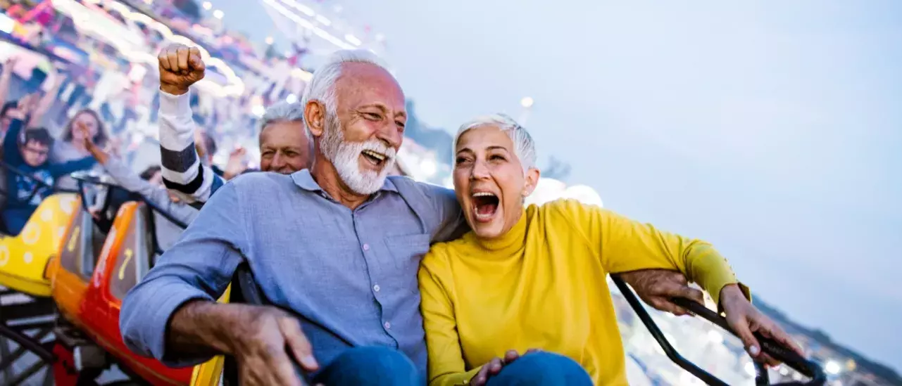 An older couple smiling on a rollercoaster ride