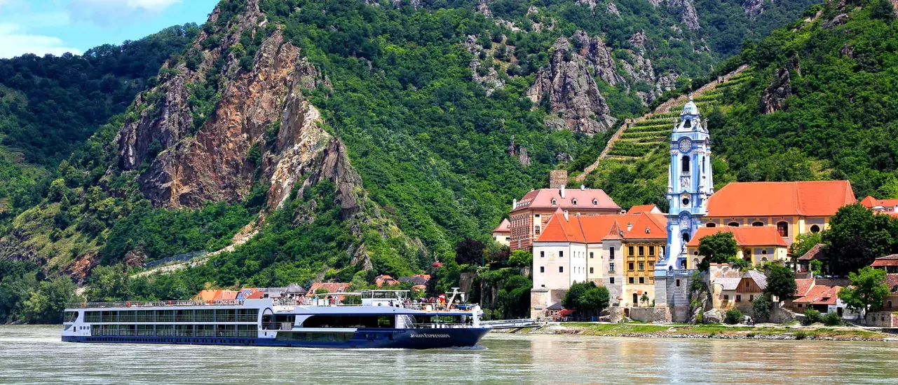 A river cruise boat floating past a European city
