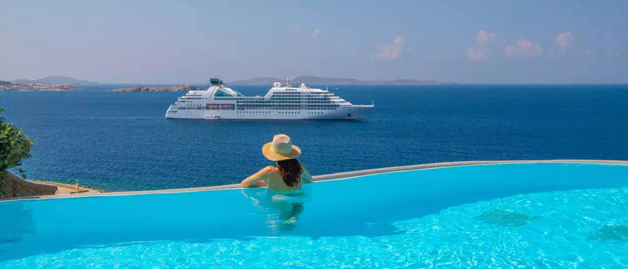 Woman in pool overlooking a Windstar ship