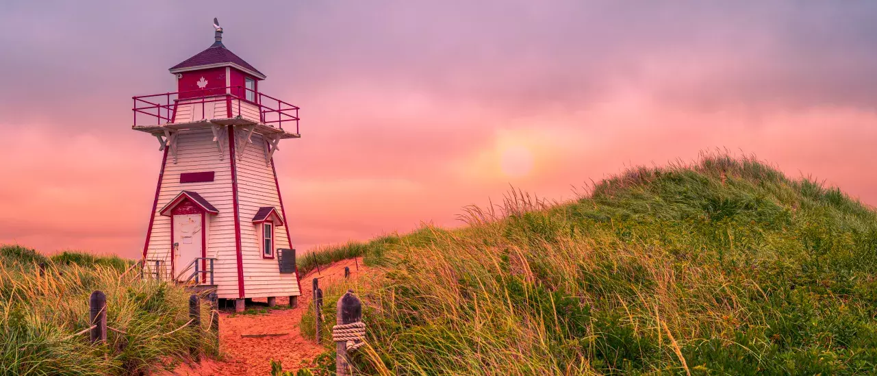 A lighthouse at sunset on a PEI beach