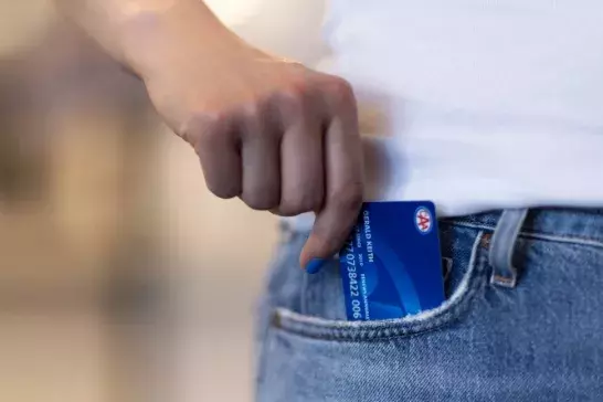 hand with blue nailpolish taking out a blue membership card from blue jeans pocket