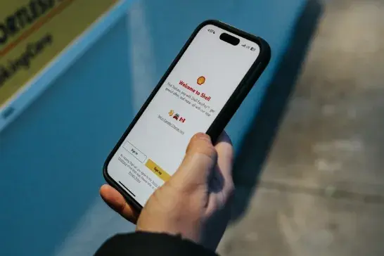 hand holding a smartphone showing an image of the Shell app