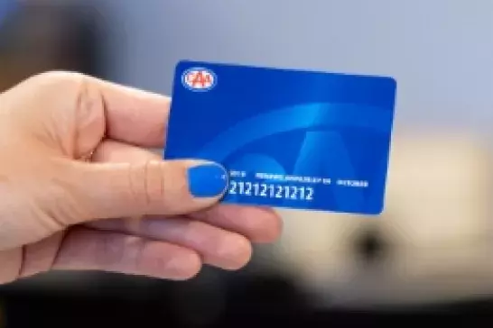 Hand with blue nailpolish holding a blue CAA membership card