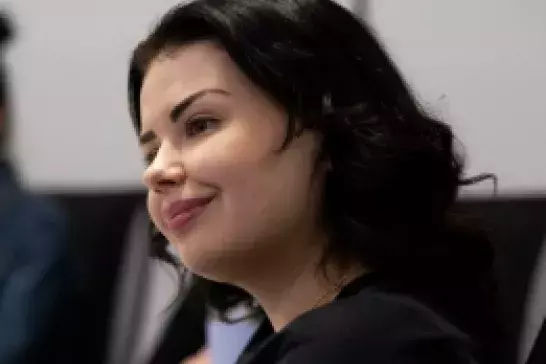 Lady wearing black shirt with black short hair smiling 