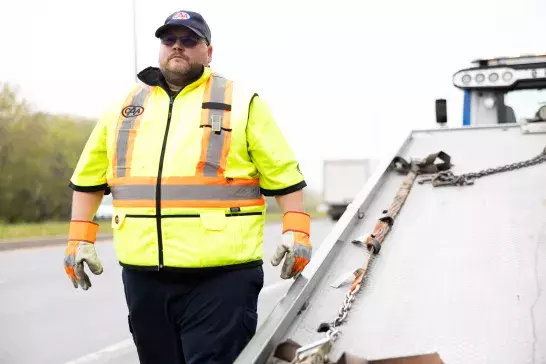 Tow truck driver purposely walking toward a member in need