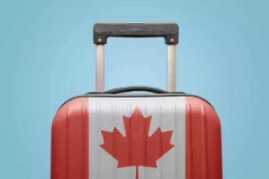 Suitcase painted with Canadian flag on light blue background