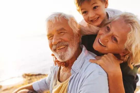 Grandparents with grandchild playing at the beach
