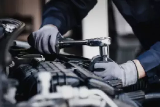 Worker working on an engine with a wrench