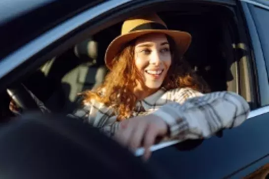 Woman smiling looking out the drivers seat window