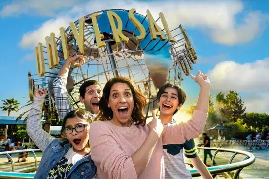 Family of four pose in front of Universal Studios statue