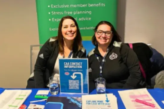 Two CAA employees set up at a travel event