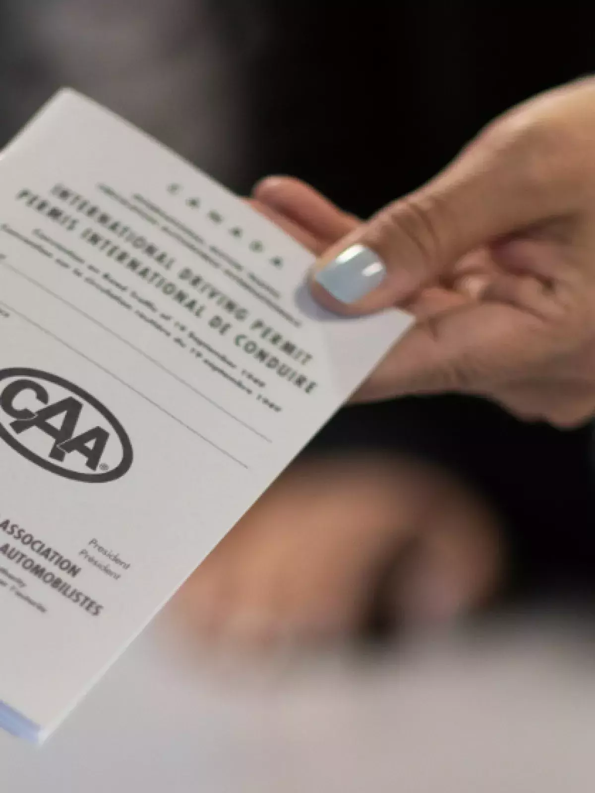 Hand holding out a CAA pamphlet