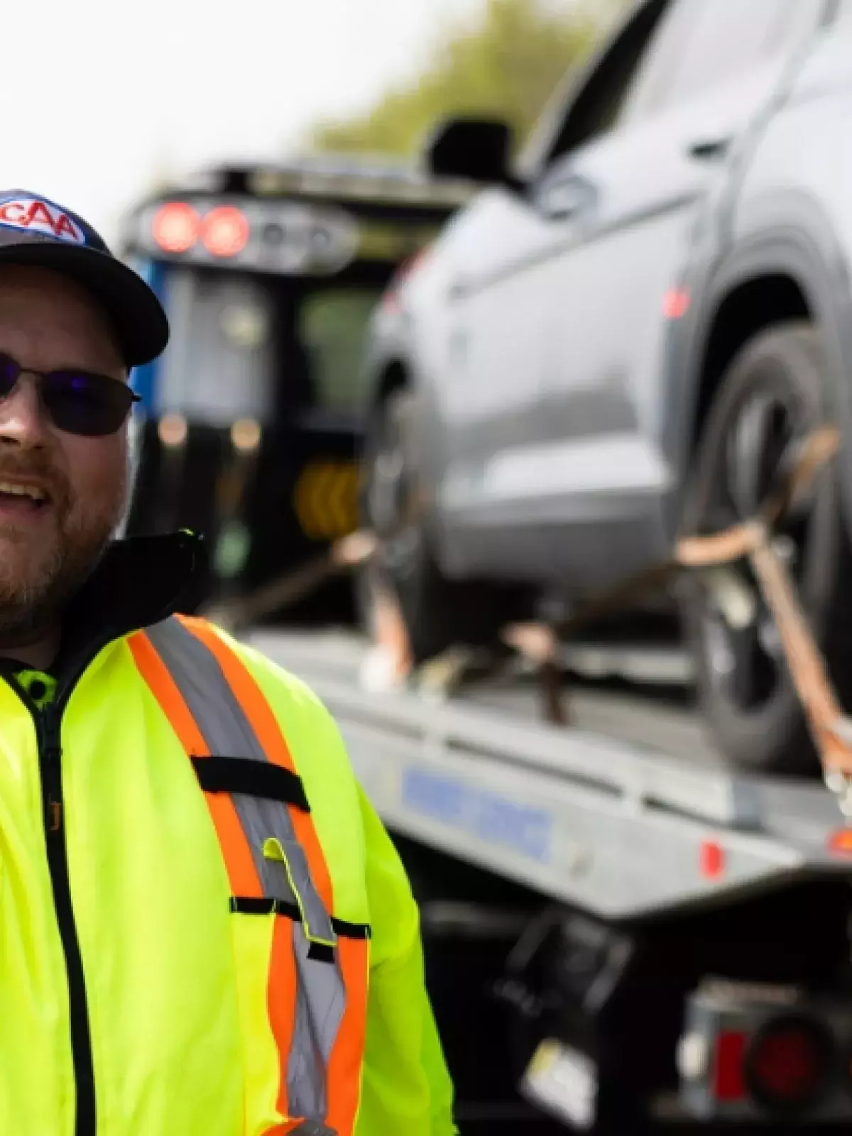 CAA roadside worker giving a thumbs up with a car in the background