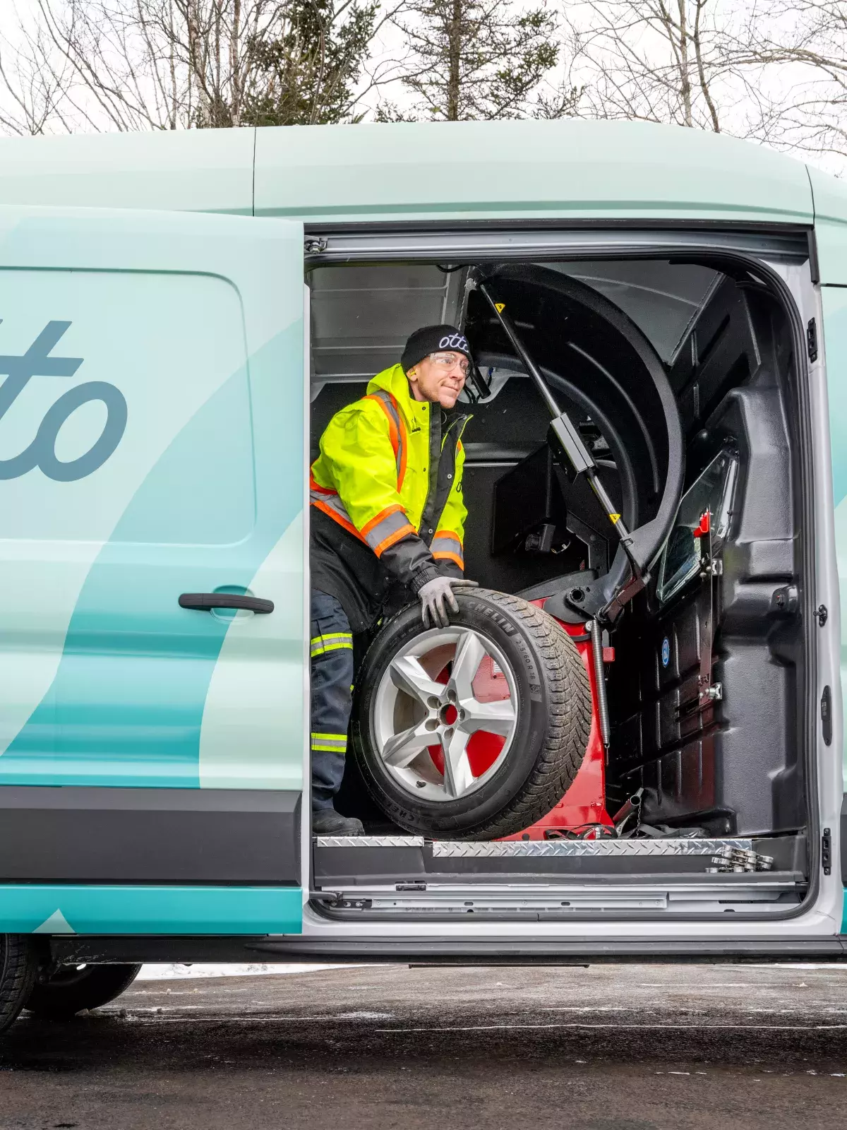 Dean, one of our Otto technicians, rolls a wheel out of his work van for a member in a driveway