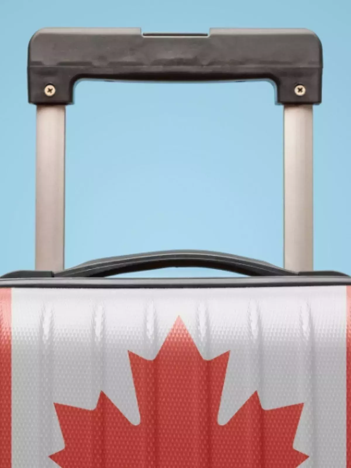 Suitcase with Canada Flag printed on it on a light blue background