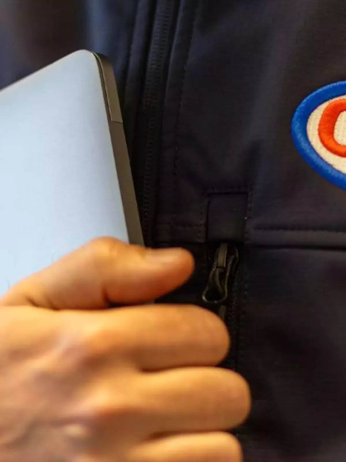 CAA agent wearing a branded CAA jacket, holding a laptop