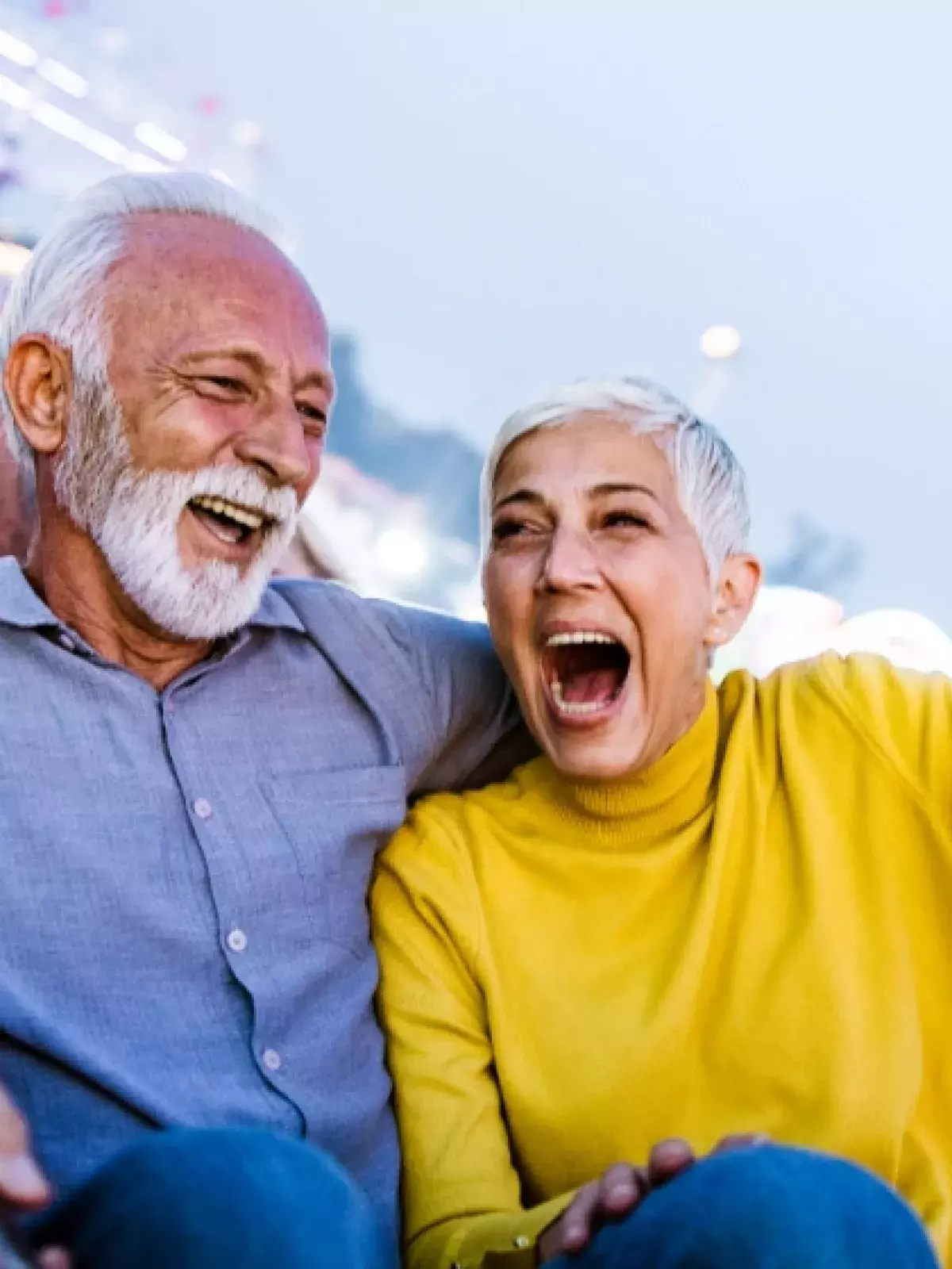 An older couple smiling on a rollercoaster ride
