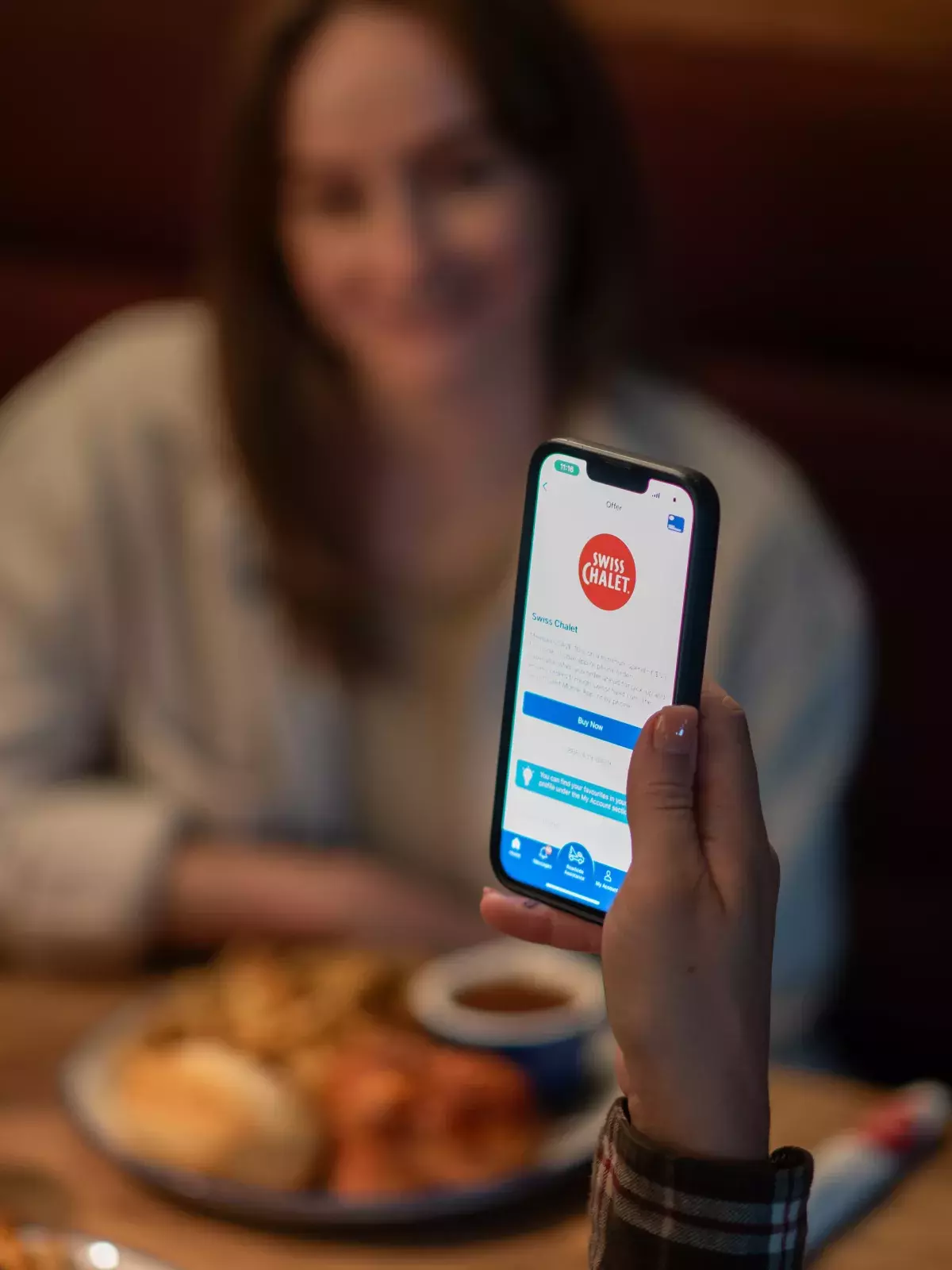 Happy customer showing CAA app at Swiss Chalet