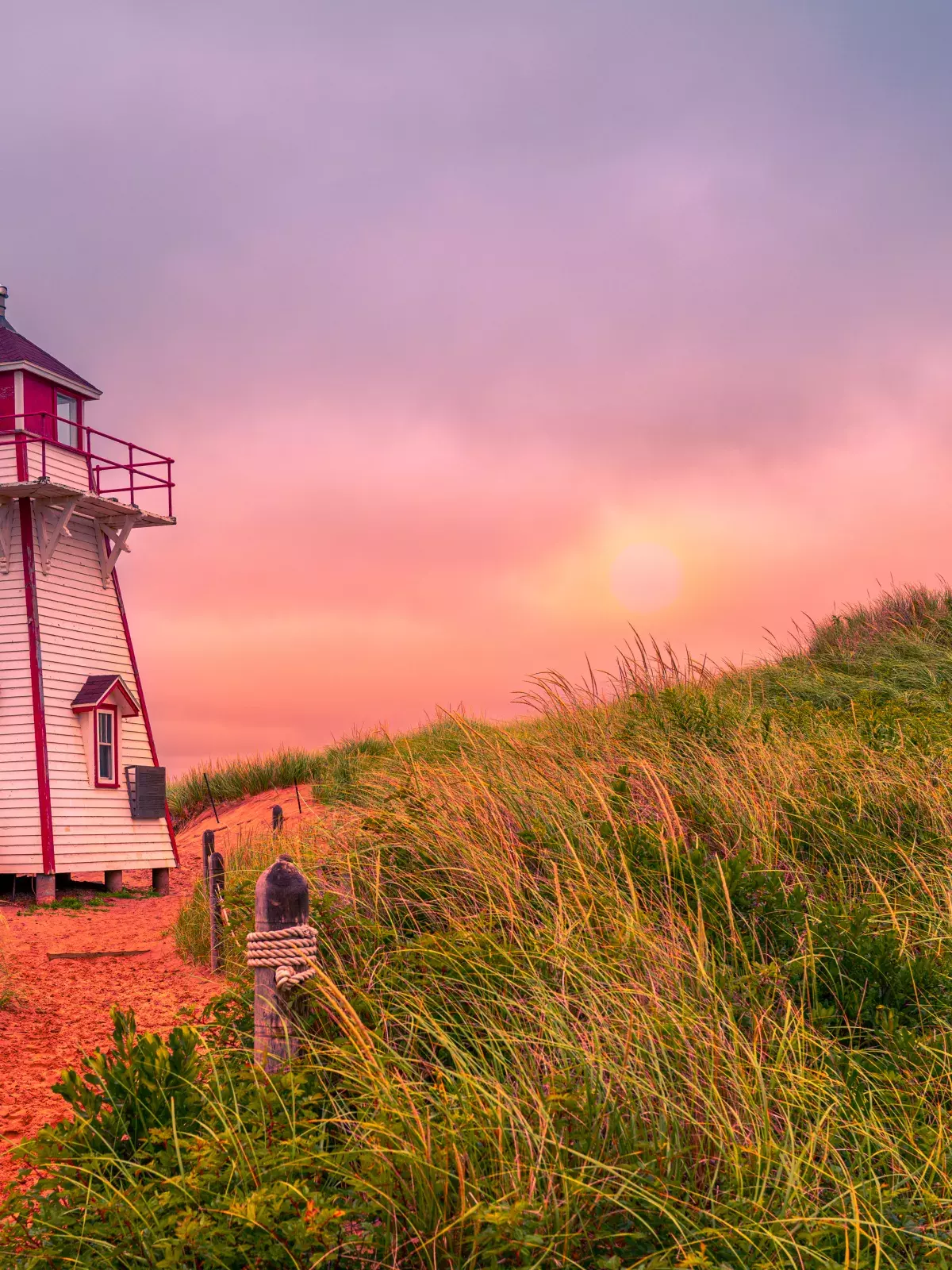 A lighthouse at sunset on a PEI beach
