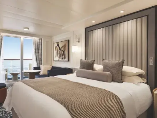 A room on an Oceania cruise ship with patio doors with an ocean view.