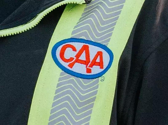 Close up shot of the CAA logo on a roadside attendants jacket