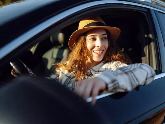 Woman smiling looking out the drivers seat window