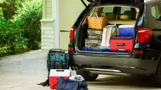 SUV packed for a roadtrip pared in the front driveway of a house