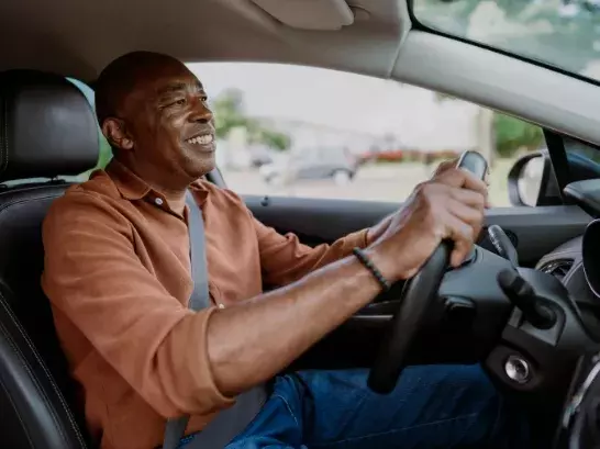 Man happily behind the wheel of a car driving