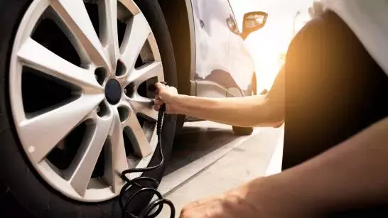 CAA mechanic inflating the tire on a customers car. 