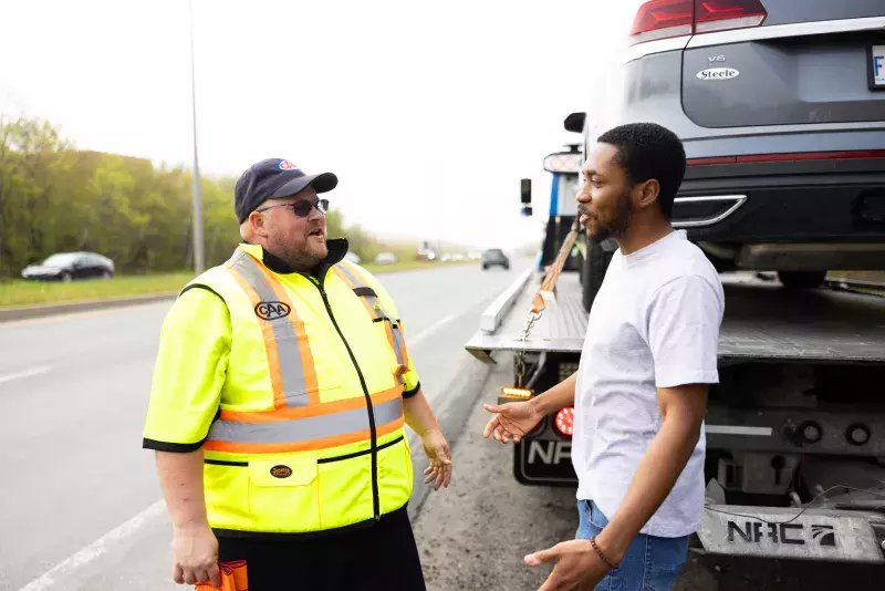 A CAA roadside technician helping a man get this vehicle towed