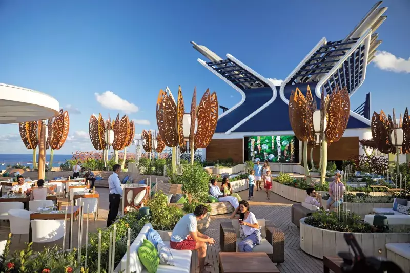 The rooftop of a Celebrity Cruises ship. People are sitting out in the sun and enjoying some beverages.