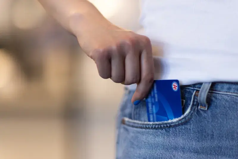 CAA membership card being placed into a jeans pocket.